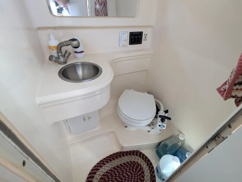 Slide: The Image of 2004 Larson Cabrio 260 boat bathroom with sink, toilet, and mirror. - 16