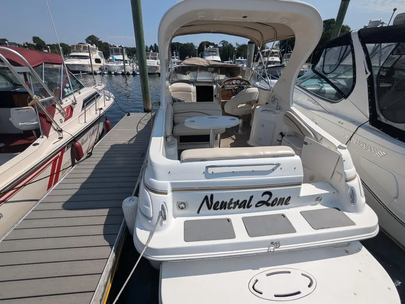 Slide: The Image of 2004 Larson Cabrio 260 boat docked at marina, featuring spacious seating and sleek design. - 2
