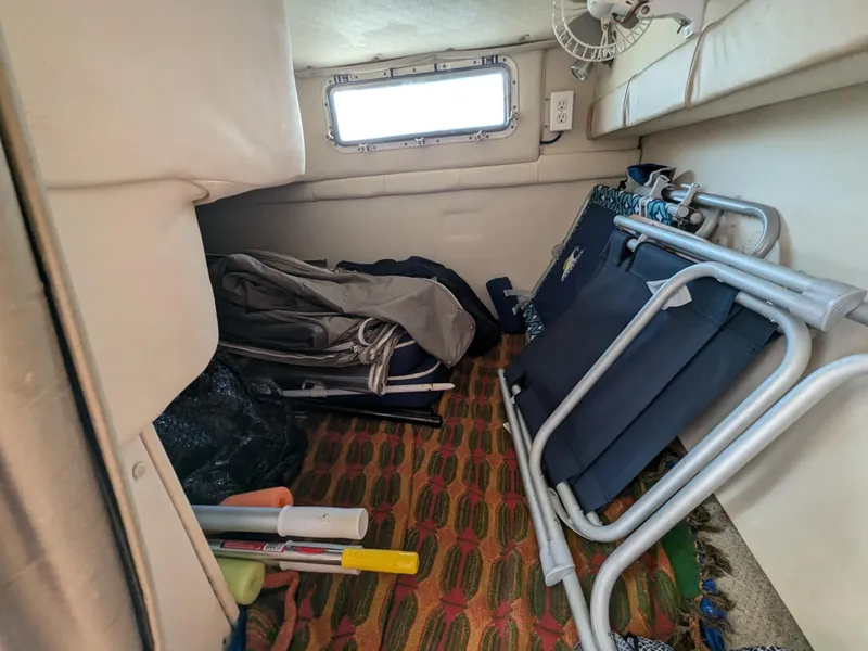 Slide: The Image of 2004 Larson Cabrio 260 cabin storage with chairs and equipment. - 22