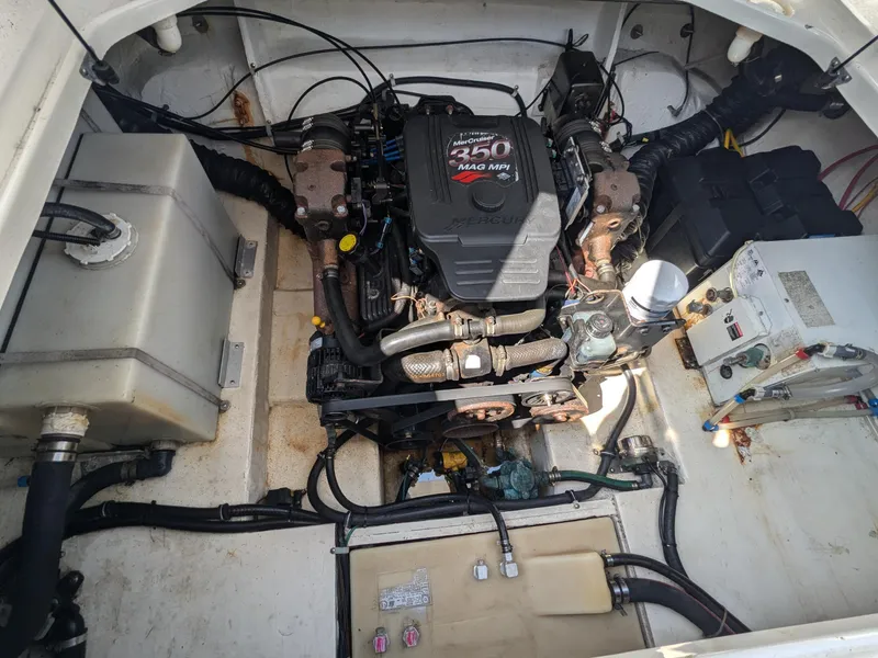 Slide: The Image of Engine compartment of a 2004 Larson Cabrio 260 boat, featuring a 250 MAG MPI engine. - 25