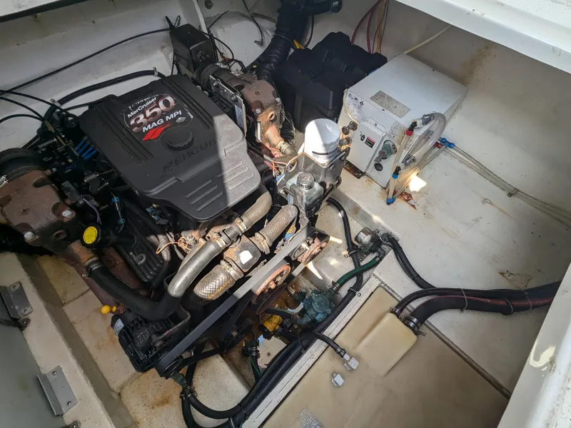 Slide: The Image of Engine compartment of a 2004 Larson Cabrio 260 boat, featuring a MerCruiser 350 MPI engine. - 26