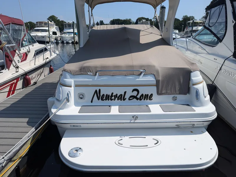 Slide: The Image of 2004 Larson Cabrio 260 boat named "Neutral Zone" docked at a marina. - 4