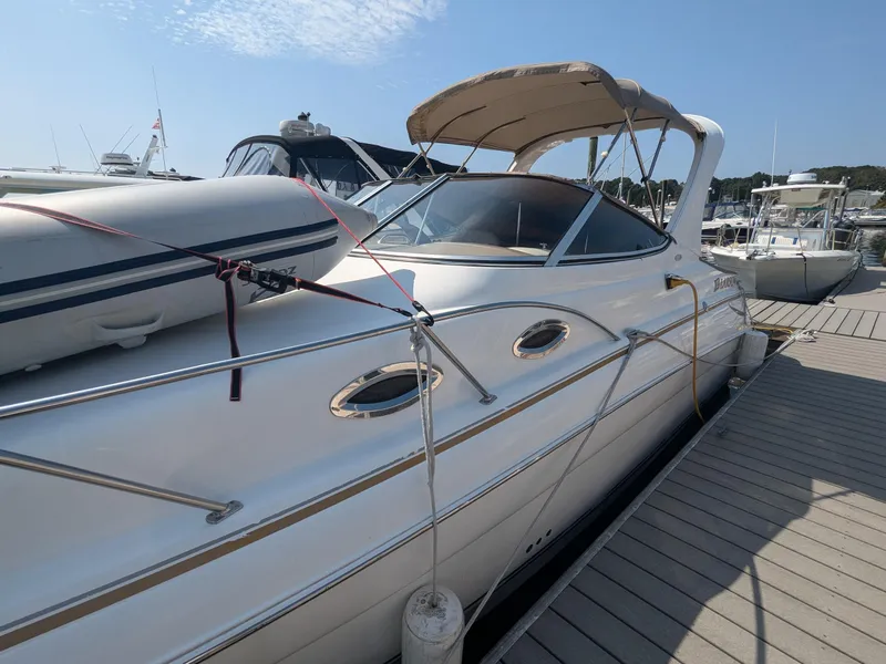 Slide: The Image of 2004 Larson Cabrio 260 boat docked at marina under clear sky. - 5