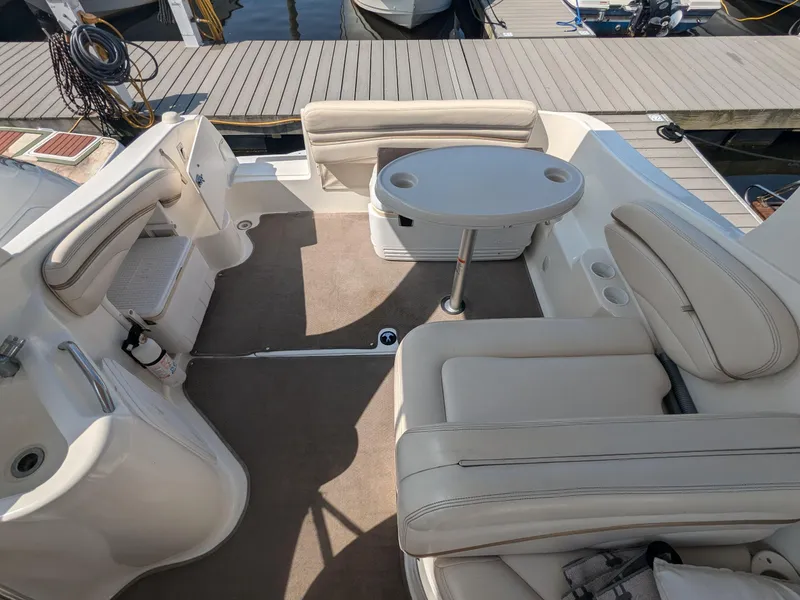 Slide: The Image of 2004 Larson Cabrio 260 boat interior with beige seating and round table. - 8