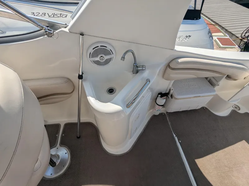 Slide: The Image of 2004 Larson Cabrio 260 boat interior with sink and seating area. - 9