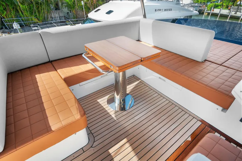 Slide: The Image of Luxurious seating area on 2023 Astondoa AS5 yacht with teak flooring and cushioned benches. - 17