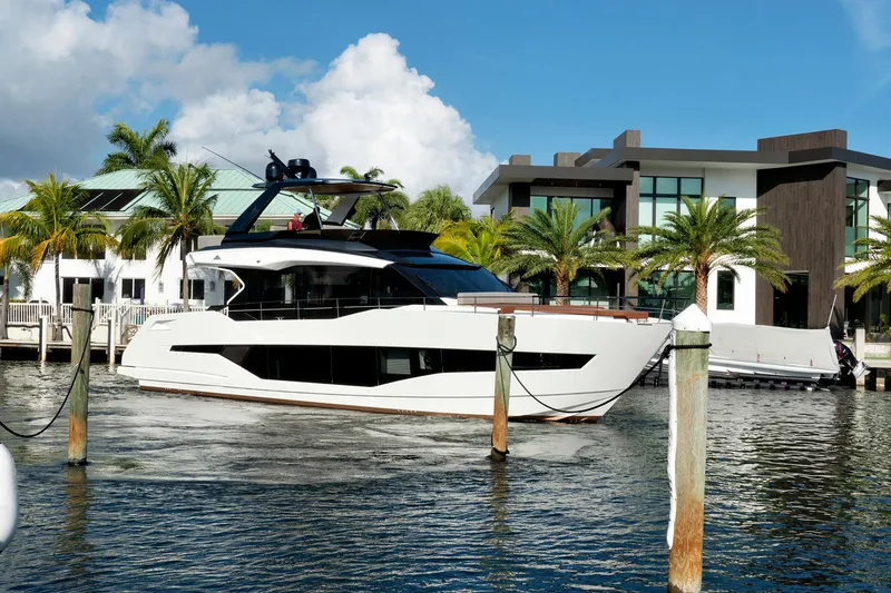 Slide: The Image of 2023 Astondoa AS5 yacht docked near modern waterfront homes. - 2