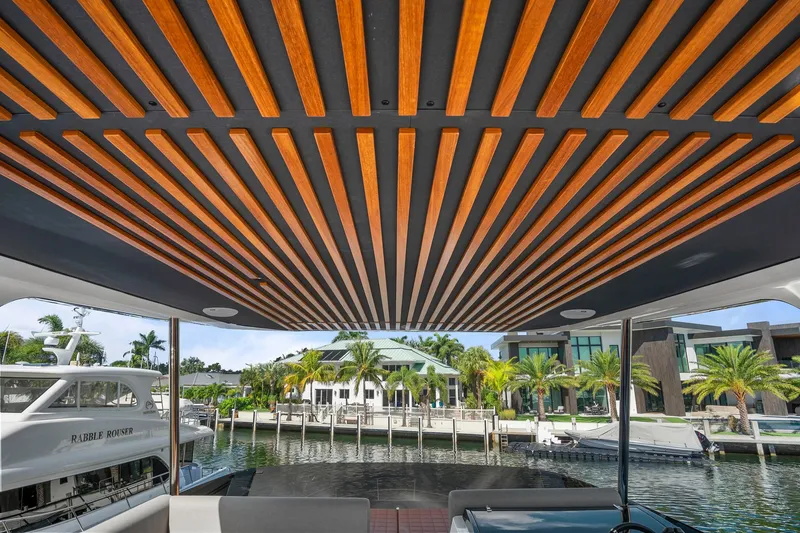 Slide: The Image of Astondoa AS5 2023 yacht with stylish wooden ceiling, docked near luxury waterfront homes. - 20