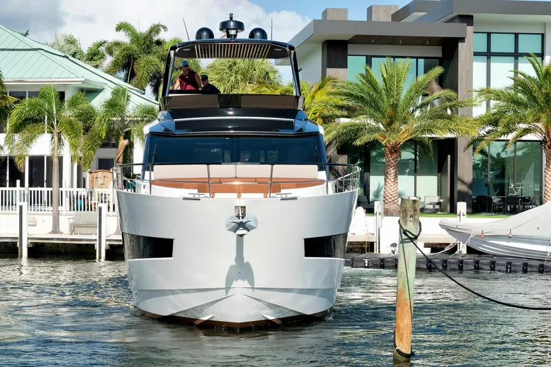 Slide: The Image of 2023 Astondoa AS5 yacht docked near modern waterfront homes and palm trees. - 3