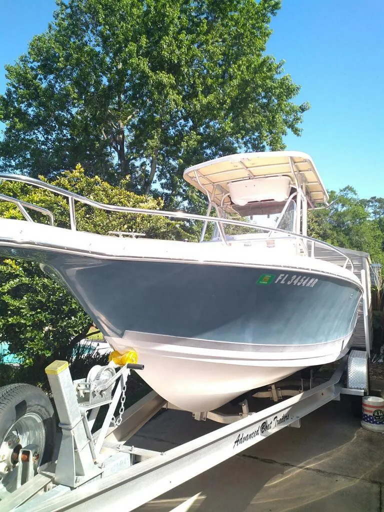The Image of 2007 Pro-Line 25 Sport boat on trailer, parked outdoors with trees in background. - 0