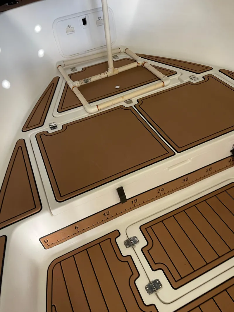 Slide: The Image of 2007 Pro-Line 25 Sport boat interior with brown deck panels and storage compartments. - 10