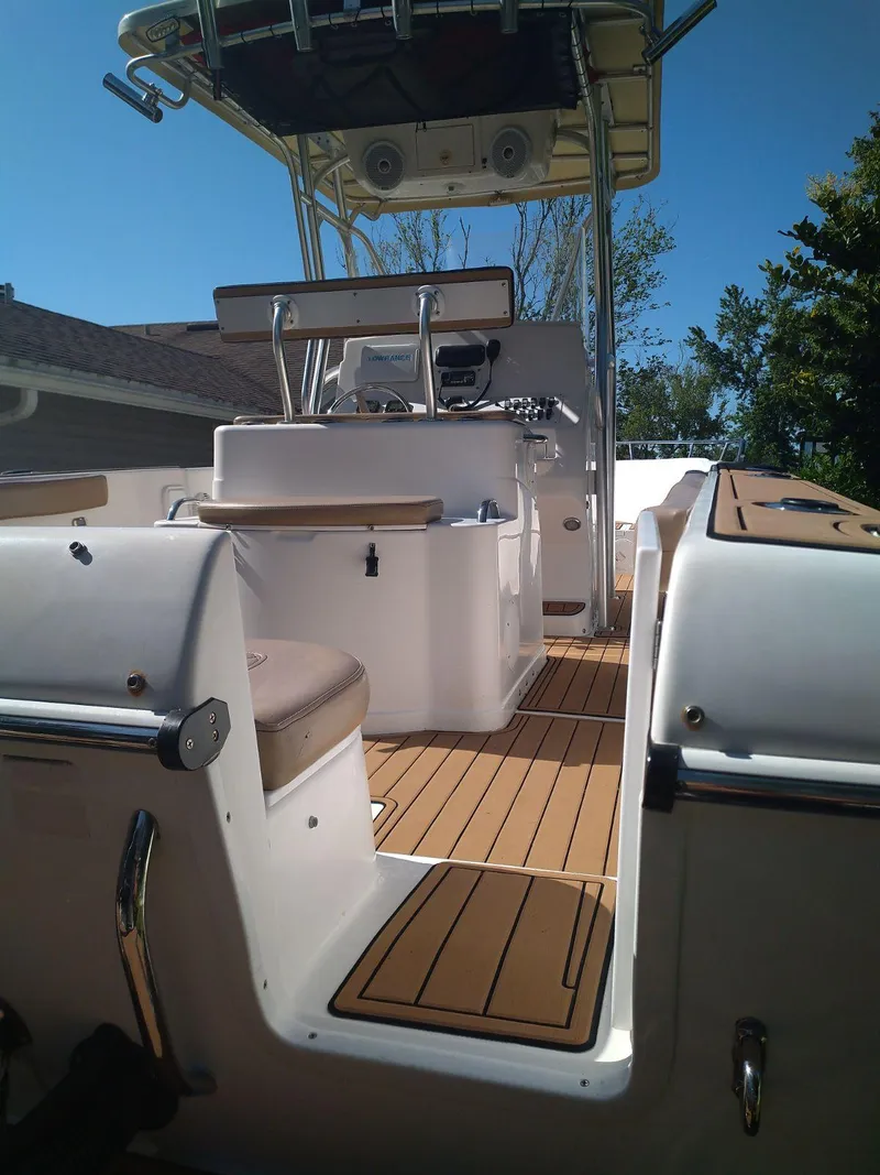 Slide: The Image of 2007 Pro-Line 25 Sport boat interior with seating and helm, featuring sleek design and wood accents. - 7