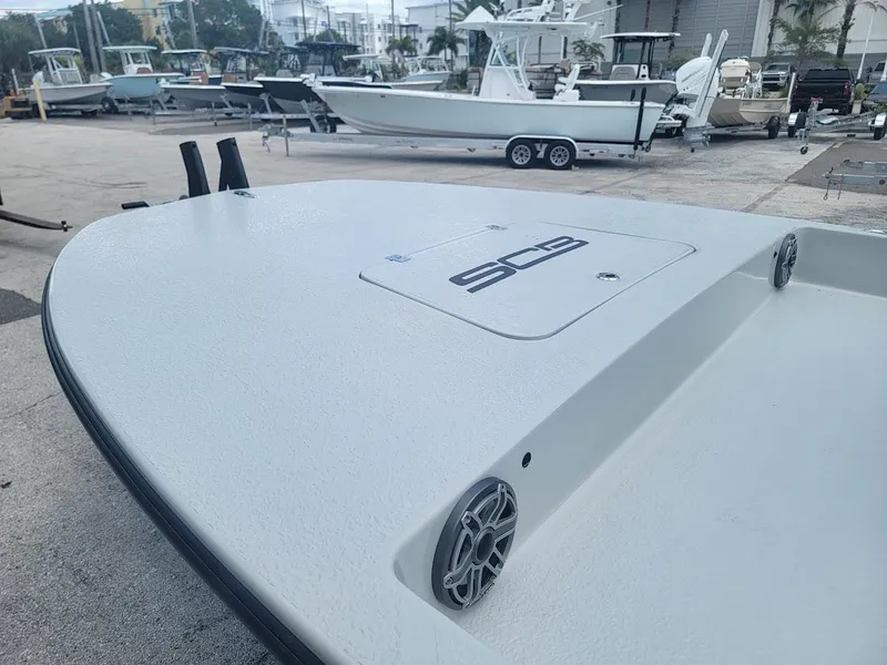 Slide: The Image of 2025 SCB S22 boat deck with speakers, parked in a marina. - 13