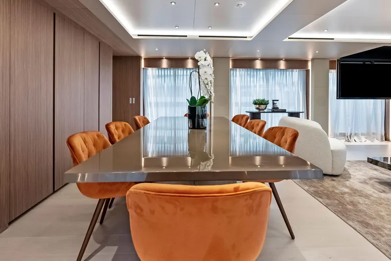 Slide: The Image of Luxurious dining area on 2023 Custom Line 106' yacht with elegant decor and orange chairs. - 12