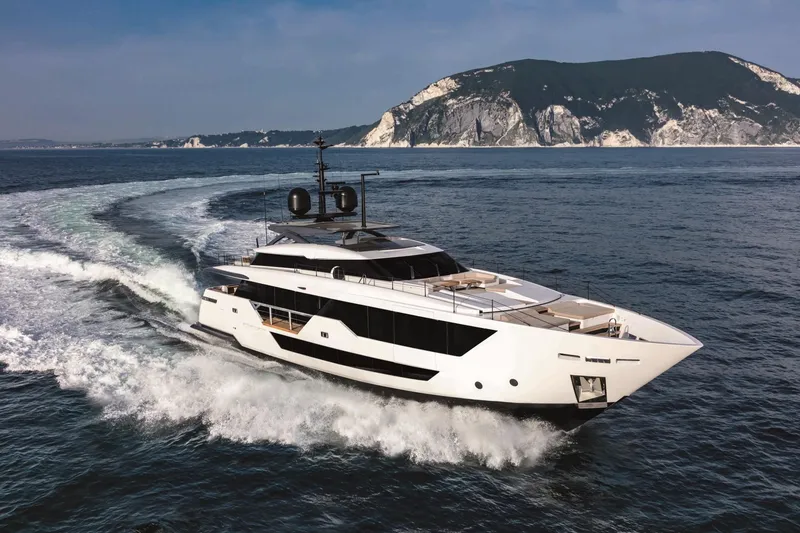 Slide: The Image of Luxurious 2023 Custom Line 106' yacht cruising near scenic coastline. - 2