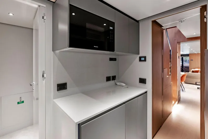 Slide: The Image of Modern kitchen area on 2023 Custom Line 106' yacht with sleek cabinetry and appliances. - 23