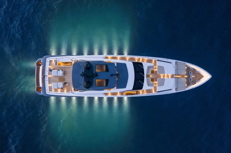 Slide: The Image of Aerial view of illuminated 2023 Custom Line 106' yacht on the water at night. - 5