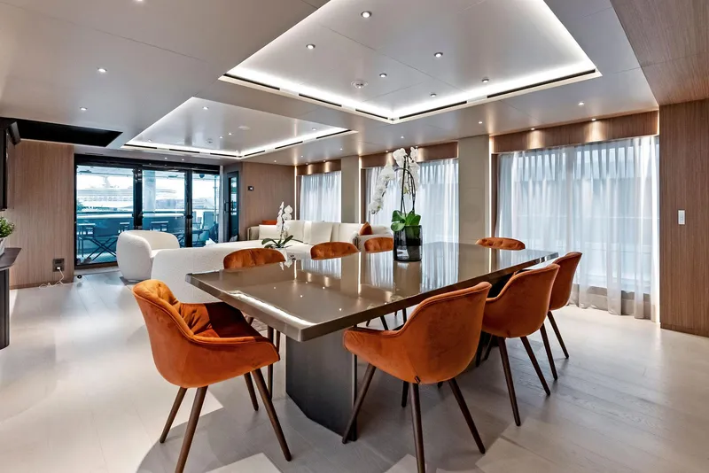 Slide: The Image of Luxurious yacht interior with modern dining area, orange chairs, and elegant lighting, 2023 Custom Line 106'. - 9