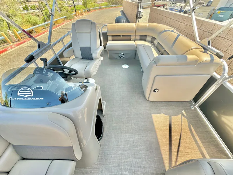 Slide: The Image of 2023 Sun Tracker Party Barge 20 DLX interior with plush seating and helm. - 11