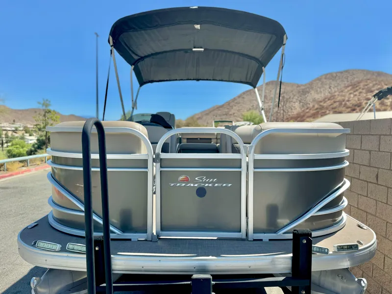 Slide: The Image of 2023 Sun Tracker Party Barge 20 DLX pontoon boat with canopy, parked outdoors. - 3