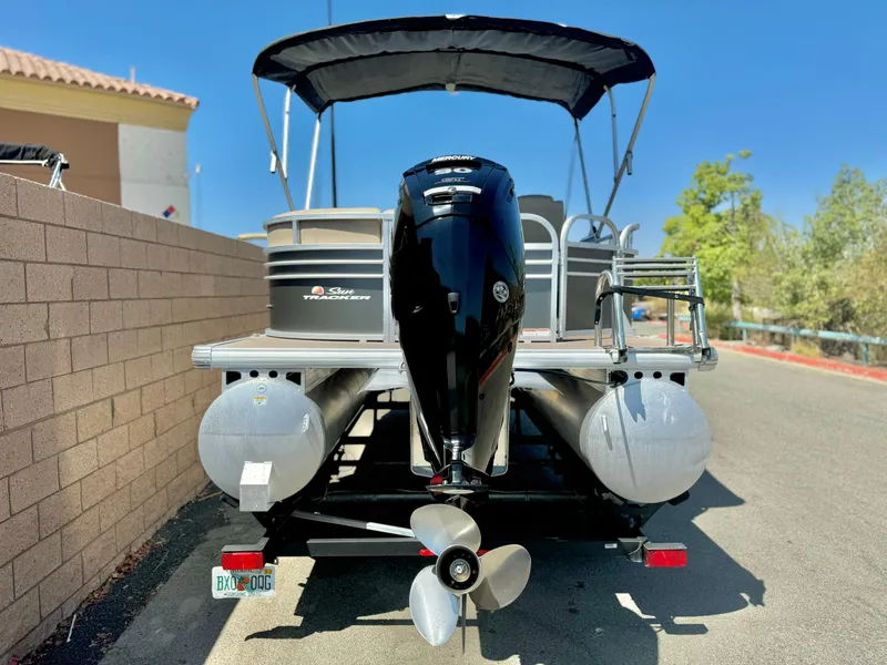 Slide: The Image of 2023 Sun Tracker Party Barge 20 DLX pontoon boat, rear view with motor and canopy. - 5
