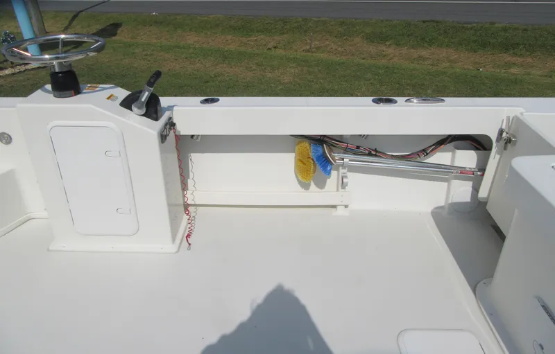 Slide: The Image of 2018 Parker 2320 SL Sport Cabin boat interior with storage and steering controls. - 12