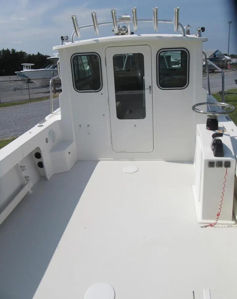 Slide: The Image of 2018 Parker 2320 SL Sport Cabin boat, spacious deck, white exterior, docked outdoors. - 14