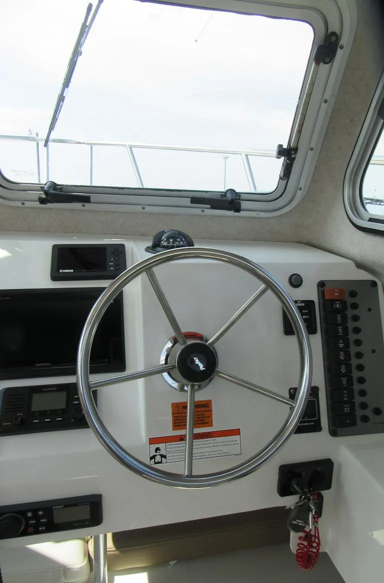 Slide: The Image of 2018 Parker 2320 SL Sport Cabin boat helm with steering wheel and control panel. - 20