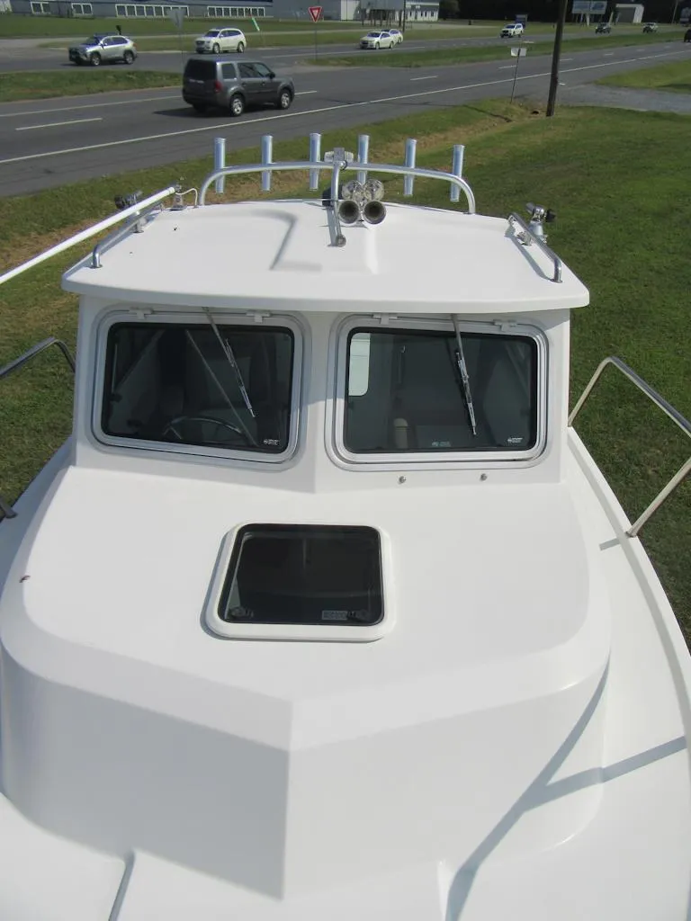 Slide: The Image of 2018 Parker 2320 SL Sport Cabin boat, front view, on grassy area near road. - 26