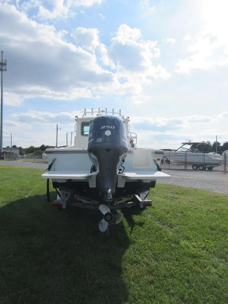 Slide: The Image of 2018 Parker 2320 SL Sport Cabin boat with outboard motor on grassy area. - 4