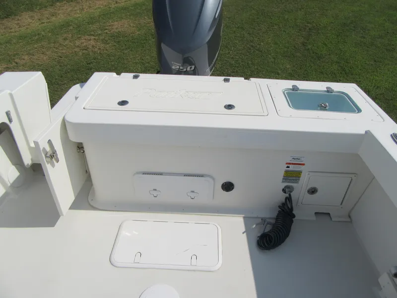 Slide: The Image of 2018 Parker 2320 SL Sport Cabin boat deck with storage compartments and outboard motor. - 9