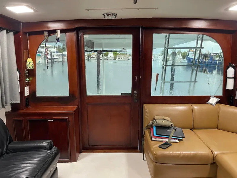 Slide: The Image of Interior of 1986 Post 43 Sport Fisher with leather seating and wooden cabinetry, overlooking marina. - 11