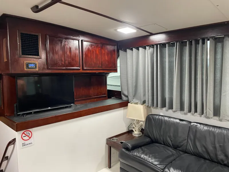 Slide: The Image of Interior of 1986 Post 43 Sport Fisher with leather sofa, TV, and wooden cabinets. - 19