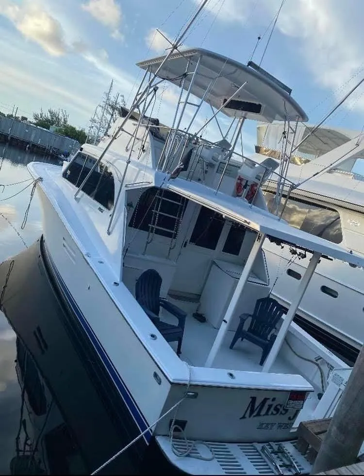 Slide: The Image of 1986 Post 43 Sport Fisher boat docked, featuring spacious deck and fishing equipment. - 2