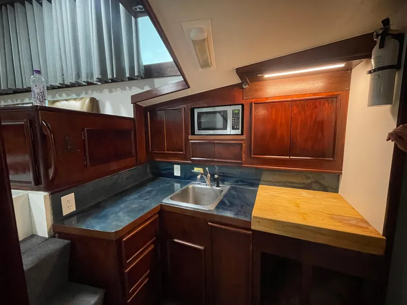 Slide: The Image of 1986 Post 43 Sport Fisher kitchen with wooden cabinets, sink, and microwave. - 29