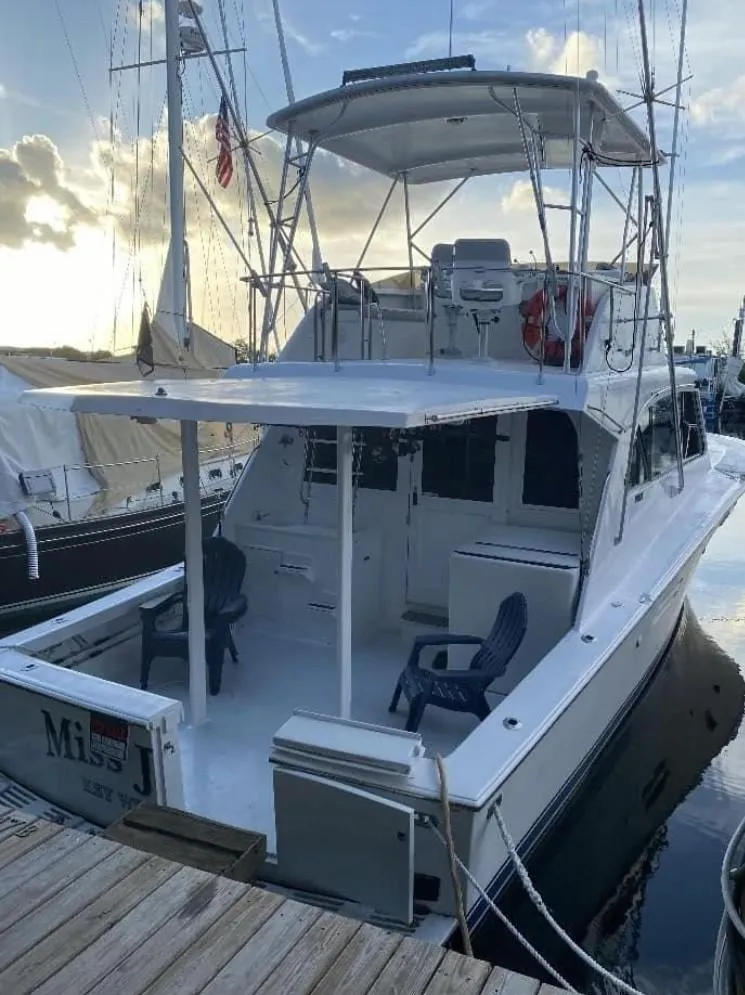 Slide: The Image of 1986 Post 43 Sport Fisher boat docked at marina, featuring spacious deck and seating. - 3