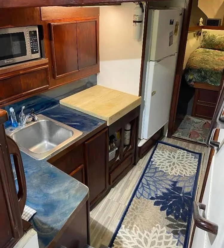 Slide: The Image of 1986 Post 43 Sport Fisher kitchen with wood cabinets, sink, microwave, and refrigerator. - 30
