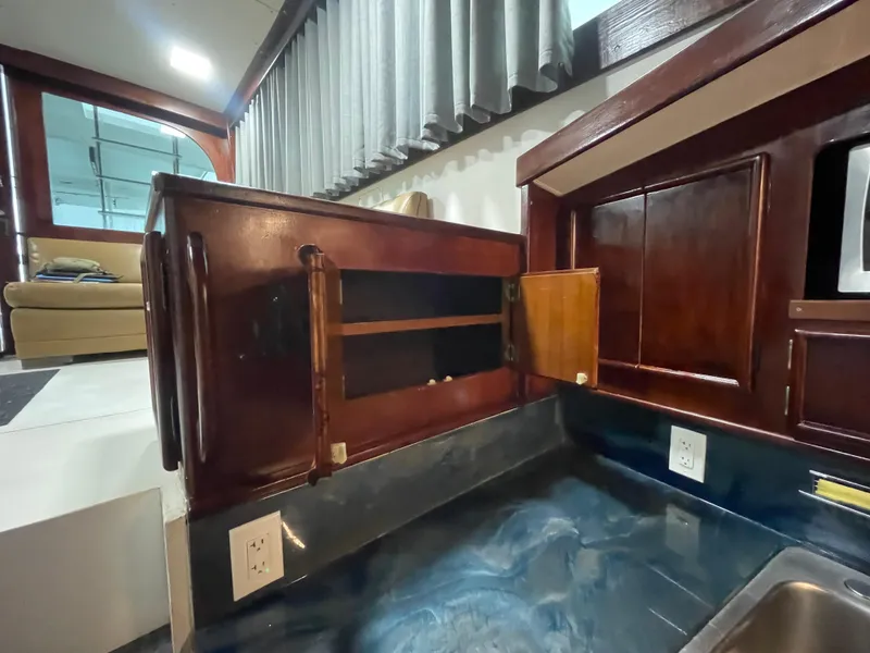 Slide: The Image of Interior of 1986 Post 43 Sport Fisher yacht, featuring wooden cabinetry and modern amenities. - 31