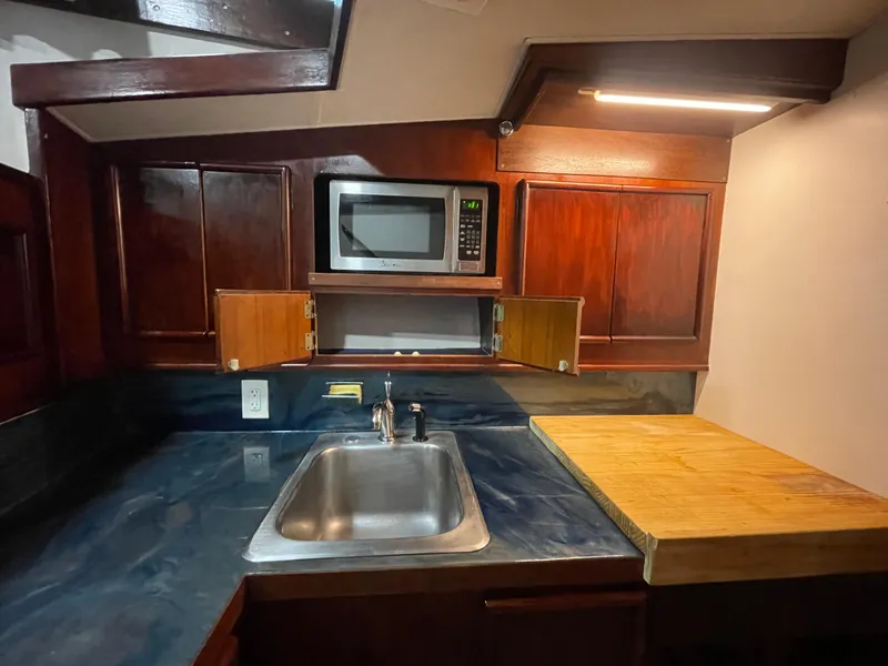 Slide: The Image of Compact kitchen in 1986 Post 43 Sport Fisher with wood cabinets, sink, and microwave. - 33