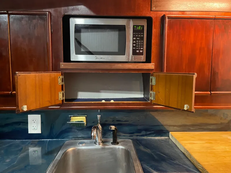 Slide: The Image of 1986 Post 43 Sport Fisher kitchen with microwave, sink, and wooden cabinets. - 34