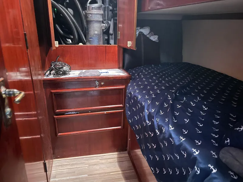 Slide: The Image of 1986 Post 43 Sport Fisher cabin interior with wooden cabinetry and anchor-patterned bedding. - 37