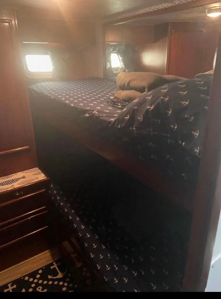 Slide: The Image of 1986 Post 43 Sport Fisher cabin with bunk beds and nautical-themed bedding. - 38