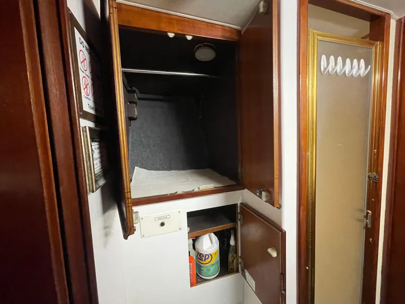Slide: The Image of Interior storage area of a 1986 Post 43 Sport Fisher boat, featuring wooden cabinets. - 42