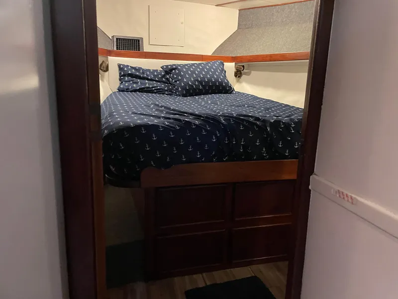 Slide: The Image of Cozy cabin bedroom in 1986 Post 43 Sport Fisher boat with nautical-themed bedding. - 48