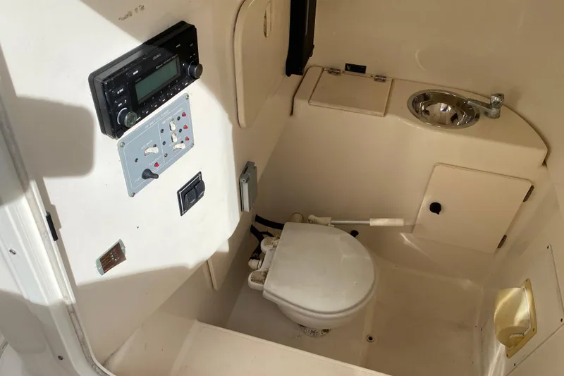 Slide: The Image of 2007 Pursuit 310 Center Console boat interior with toilet and sink. - 17