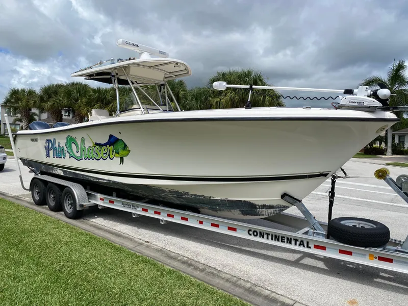 Slide: The Image of 2007 Pursuit 310 Center Console boat on trailer in residential area. - 2