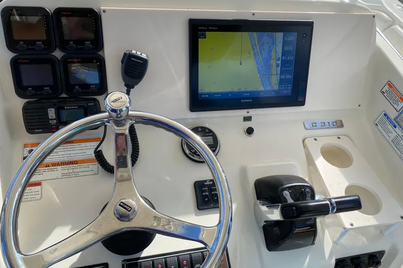 Slide: The Image of 2007 Pursuit 310 Center Console helm with steering wheel, navigation display, and controls. - 21