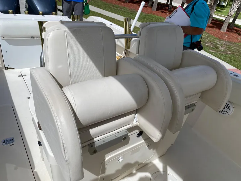 Slide: The Image of 2007 Pursuit 310 Center Console boat seats, white leather, outdoor setting. - 26
