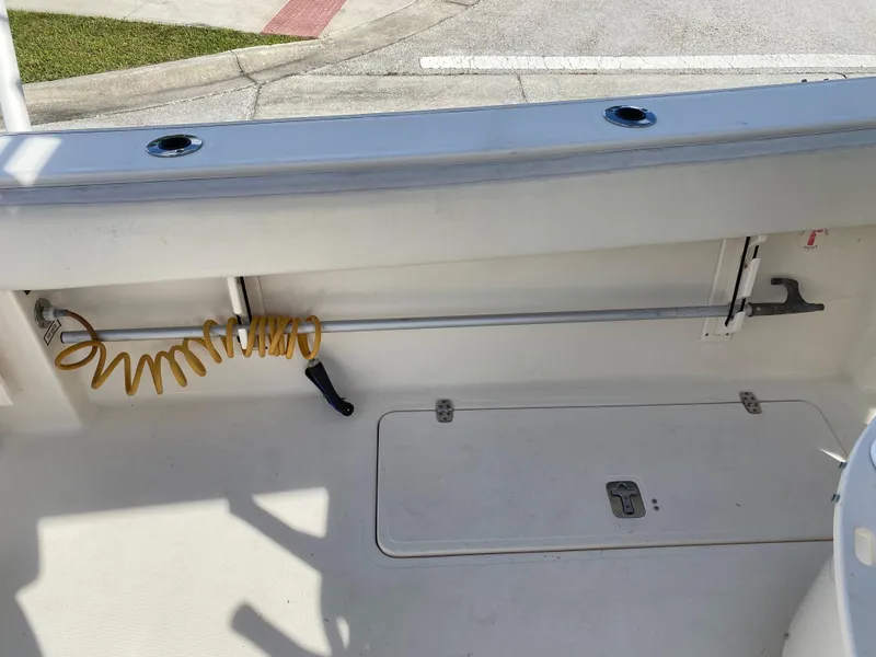 Slide: The Image of 2007 Pursuit 310 Center Console boat deck with storage and coiled hose. - 33
