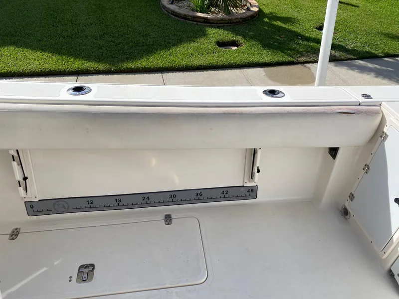 Slide: The Image of 2007 Pursuit 310 Center Console boat interior with measuring ruler and storage compartments. - 34
